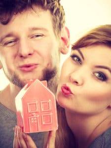 Couple share kisses with house symbol.